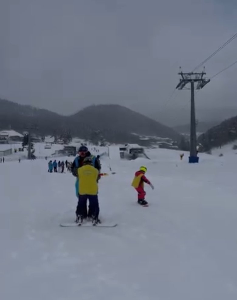 Teaching a child to snowboard